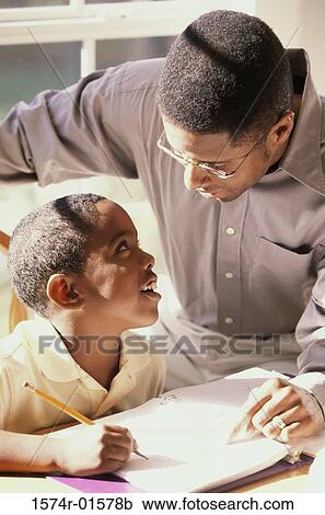 Stock Image - High angle view of a father teaching his son. Fotosearch