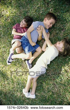 High angle view of a girl and two boys playing in a park View Large Photo Image Stock Image - High angle view of a girl and two boys playing in a park. Fotosearch
