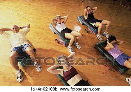Stock Image - High angle view of a group of people exercising in a step aerobics class. Fotosearch