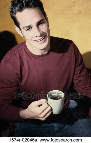 High angle view of a man holding a cup of coffee View Large Photo Image Stock Image - High angle view of a man holding a cup of coffee. Fotosearch