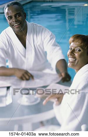 High angle view of a mature couple in bathrobes having breakfast by a swimming pool View Large Photo Image Stock Image - High angle view of a mature couple in bathrobes having breakfast by a swimming pool. Fotosearch