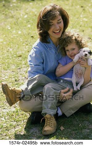 High angle view of a mother and her daughter playing with puppies View Large Photo Image Stock Image - High angle view of a mother and her daughter playing with puppies. Fotosearch