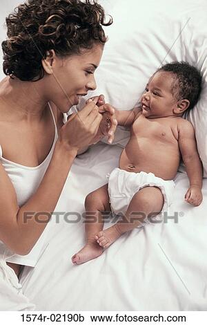 Stock Image - High angle view of a mother playing with her baby boy. Fotosearch