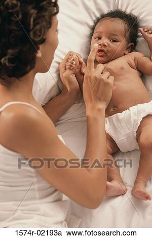 Stock Image - High angle view of a mother playing with her baby boy. Fotosearch