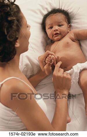 Stock Image - High angle view of a mother playing with her baby boy. Fotosearch