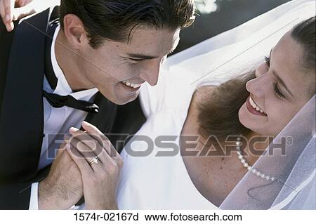 Stock Image - High angle view of a newlywed couple looking at each other. Fotosearch