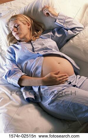High angle view of a pregnant woman sleeping on a bed View Large Photo Image Picture - High angle view of a pregnant woman sleeping on a bed. Fotosearch