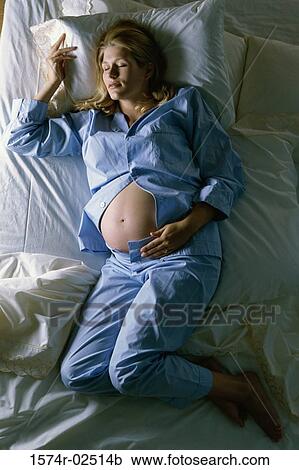 High angle view of a pregnant woman sleeping on a bed View Large Photo Image Stock Image - High angle view of a pregnant woman sleeping on a bed. Fotosearch