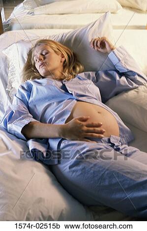 High angle view of a pregnant woman sleeping on a bed View Large Photo Image Stock Image - High angle view of a pregnant woman sleeping on a bed. Fotosearch