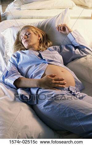 High angle view of a pregnant woman sleeping on a bed View Large Photo Image Stock Image - High angle view of a pregnant woman sleeping on a bed. Fotosearch