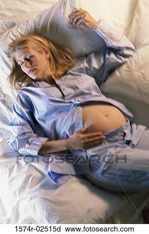 High angle view of a pregnant woman sleeping on a bed View Large Photo Image Stock Image - High angle view of a pregnant woman sleeping on a bed. Fotosearch