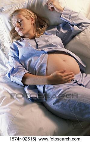 High angle view of a pregnant woman sleeping on a bed View Large Photo Image Stock Image - High angle view of a pregnant woman sleeping on a bed. Fotosearch