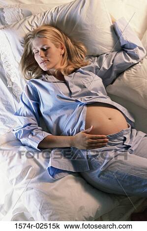 High angle view of a pregnant woman sleeping on a bed View Large Photo Image Stock Image - High angle view of a pregnant woman sleeping on a bed. Fotosearch