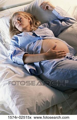 High angle view of a pregnant woman sleeping on a bed View Large Photo Image Stock Photo - High angle view of a pregnant woman sleeping on a bed. Fotosearch
