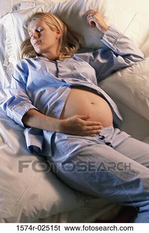 High angle view of a pregnant woman sleeping on a bed View Large Photo Image Stock Photograph - High angle view of a pregnant woman sleeping on a bed. Fotosearch