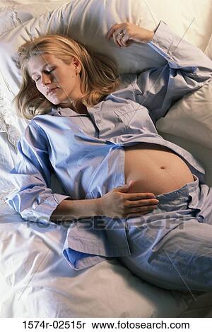 High angle view of a pregnant woman sleeping on a bed View Large Photo Image Stock Photography - High angle view of a pregnant woman sleeping on a bed. Fotosearch