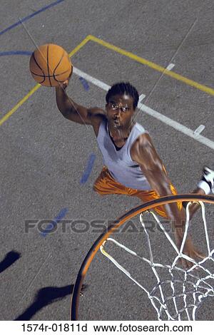 High angle view of a young man playing basketball View Large Photo Image Stock Image - High angle view of a young man playing basketball. Fotosearch