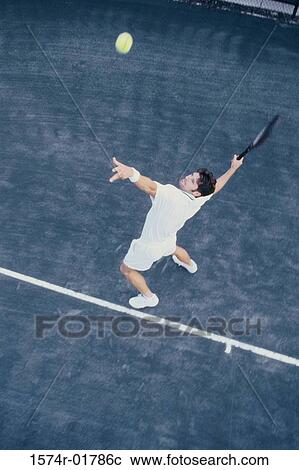 High angle view of man serving a tennis ball View Large Photo Image Stock Image - High angle view of man serving a tennis ball. Fotosearch