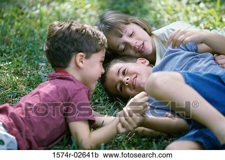 High angle view of two boys and a girl playing on a lawn View Large Photo Image Stock Image - High angle view of two boys and a girl playing on a lawn. Fotosearch