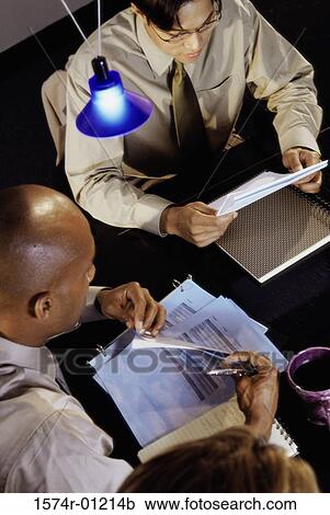 Stock Image - High angle view of two businessmen reading documents. Fotosearch