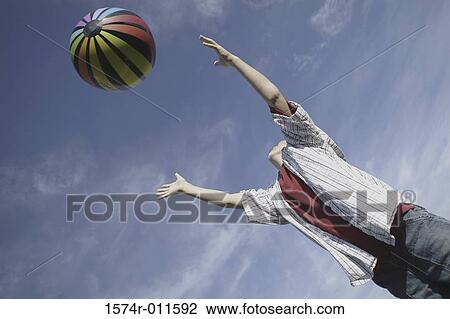 Low angle view of a boy playing with a ball View Large Photo Image Stock Image - Low angle view of a boy playing with a ball. Fotosearch