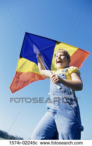 Low angle view of a girl holding a kite View Large Photo Image Stock Image - Low angle view of a girl holding a kite. Fotosearch