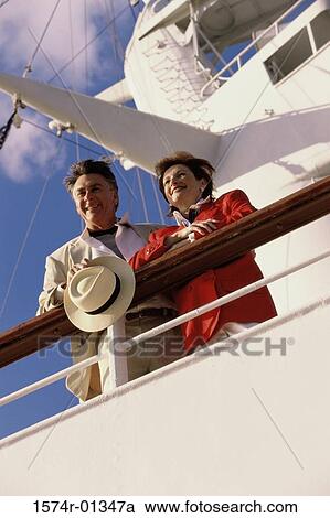 Stock Image - Low angle view of a mature couple on a cruise ship. Fotosearch