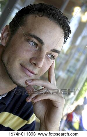 Low angle view of a young man smiling View Large Photo Image Stock Image - Low angle view of a young man smiling. Fotosearch