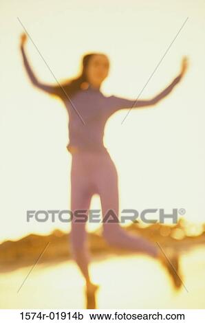 Low angle view of a young woman dancing View Large Photo Image Stock Image - Low angle view of a young woman dancing. Fotosearch