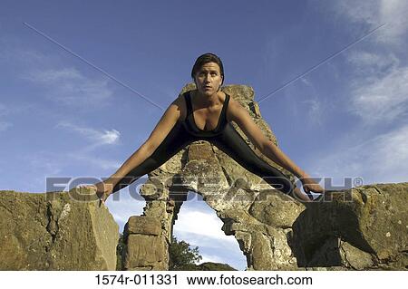 Low angle view of a young woman exercising on a rock View Large Photo Image Stock Image - Low angle view of a young woman exercising on a rock. Fotosearch