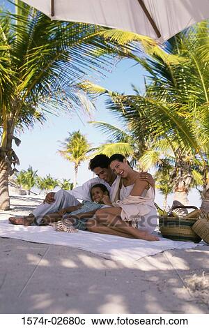 Low angle view of parents sitting with their daughter on the beach View Large Photo Image Stock Image - Low angle view of parents sitting with their daughter on the beach. Fotosearch