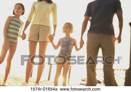 Stock Image - Low angle view of parents with their two daughters. Fotosearch