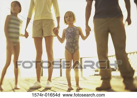 Stock Image - Low angle view of parents with their two daughters. Fotosearch