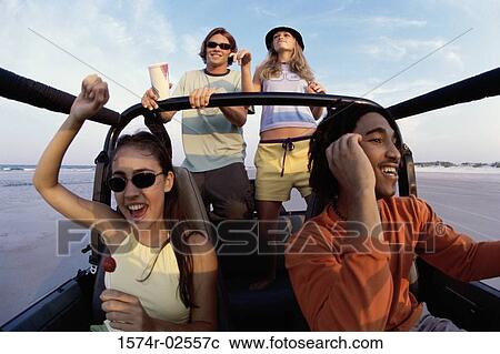 Stock Image - Low angle view of two young couples in a jeep. Fotosearch