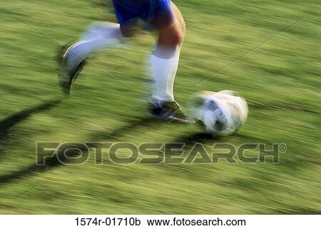 Low section view of a soccer player running with the ball View Large Photo Image Stock Image - Low section view of a soccer player running with the ball. Fotosearch