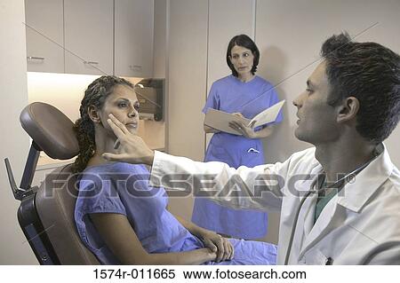 Stock Photography - Male doctor examining a female patient. Fotosearch