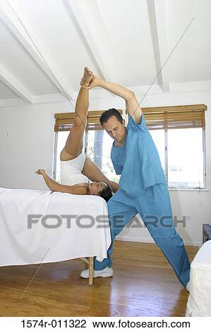 Man helping a young woman stretch View Large Photo Image Stock Image - Man helping a young woman stretch. Fotosearch