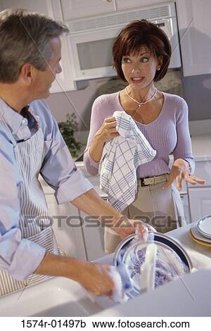 Stock Image - Mature couple washing dishes together. Fotosearch