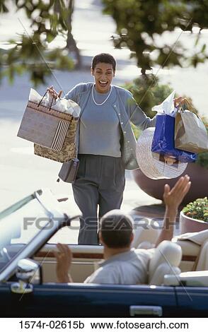 Stock Image - Mature woman carrying shopping bags. Fotosearch