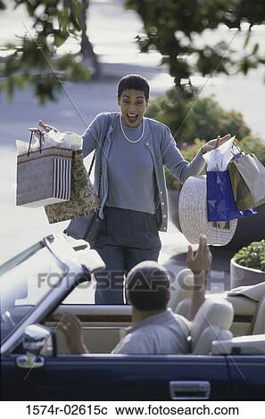 Stock Image - Mature woman carrying shopping bags. Fotosearch
