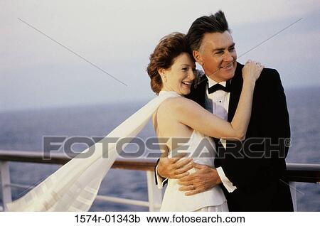Mid adult couple holding each other on a cruise ship View Large Photo Image Stock Image - Mid adult couple holding each other on a cruise ship. Fotosearch
