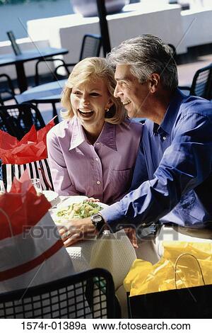 Mid adult couple sitting together smiling View Large Photo Image Stock Image - Mid adult couple sitting together smiling. Fotosearch