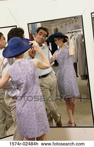 Mid adult couple standing in front of a mirror in the fitting room of a clothing store View Large Photo Image Stock Image - Mid adult couple standing in front of a mirror in the fitting room of a clothing store. Fotosearch