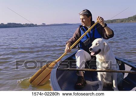 Mid adult man sitting in a row boat with his dog View Large Photo Image Stock Image - Mid adult man sitting in a row boat with his dog. Fotosearch