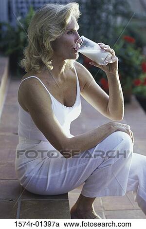 Mid adult woman drinking a glass of milk View Large Photo Image Stock Image - Mid adult woman drinking a glass of milk. Fotosearch