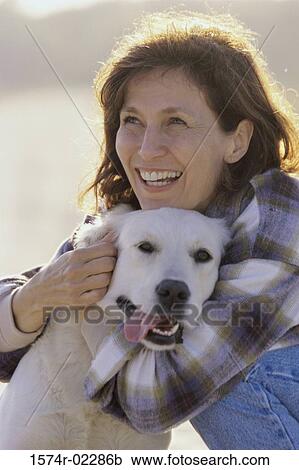Mid adult woman holding her dog View Large Photo Image Stock Image - Mid adult woman holding her dog. Fotosearch