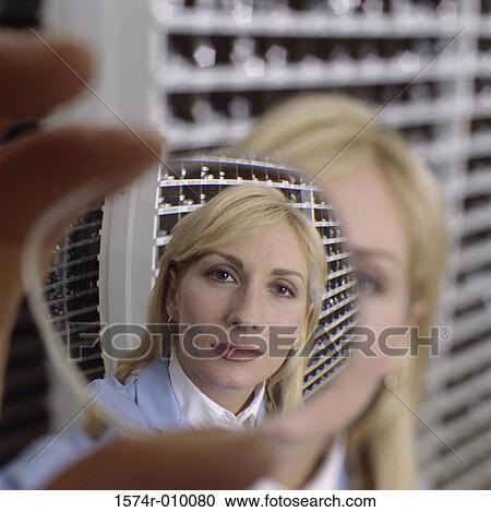 Mid adult woman looking through a lens View Large Photo Image Stock Image - Mid adult woman looking through a lens. Fotosearch