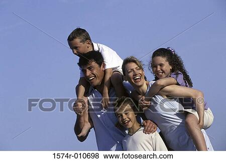 Mother and father on the beach with their three children View Large Photo Image Stock Photo - Mother and father on the beach with their three children. Fotosearch