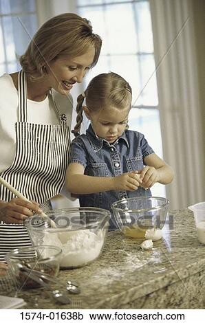 Stock Image - Mother and her daughter baking together in the kitchen. Fotosearch