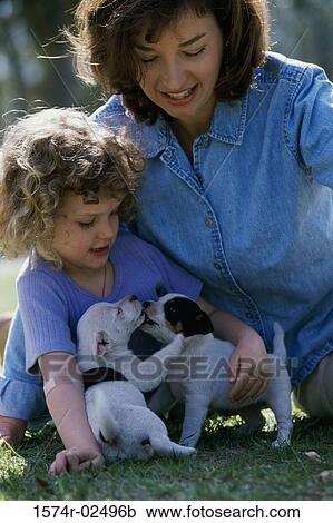Mother and her daughter playing with puppies View Large Photo Image Stock Image - Mother and her daughter playing with puppies. Fotosearch